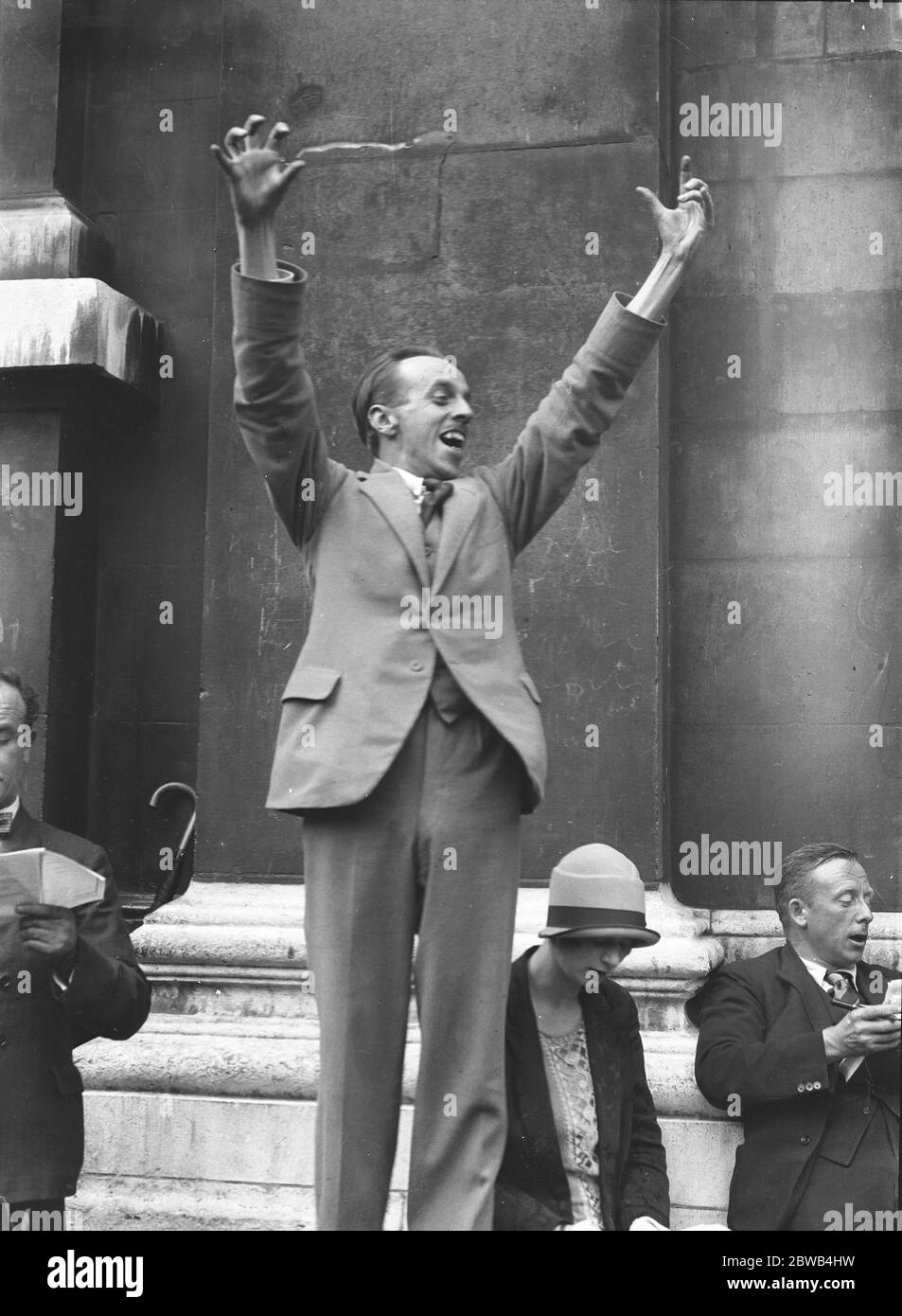 Herr Gibson Young , Organisator Sekretär der Community Singers Association , dirigiert ein Open-Air-Sing - Lied auf dem Kirchhof von St Martins in the Fields , London . Juli 1926 Stockfoto