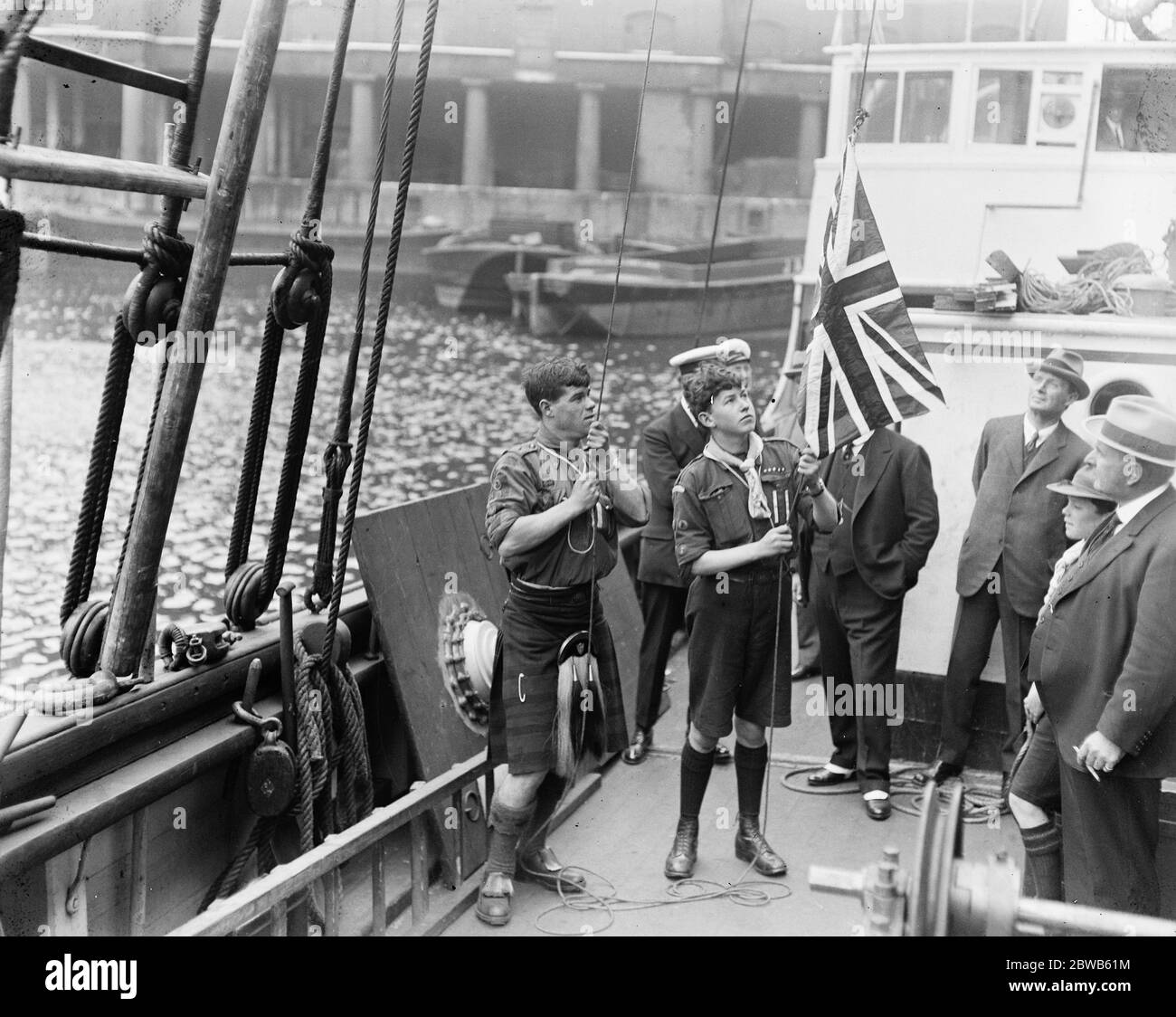Die Shackleton - Rowett Expedition segelt in die Antarktis. Scouts, James Marr und Norman Mooney, zwei der Crew, die die Flagge des Königs vor dem Start hissen. 17. September 1921 Stockfoto