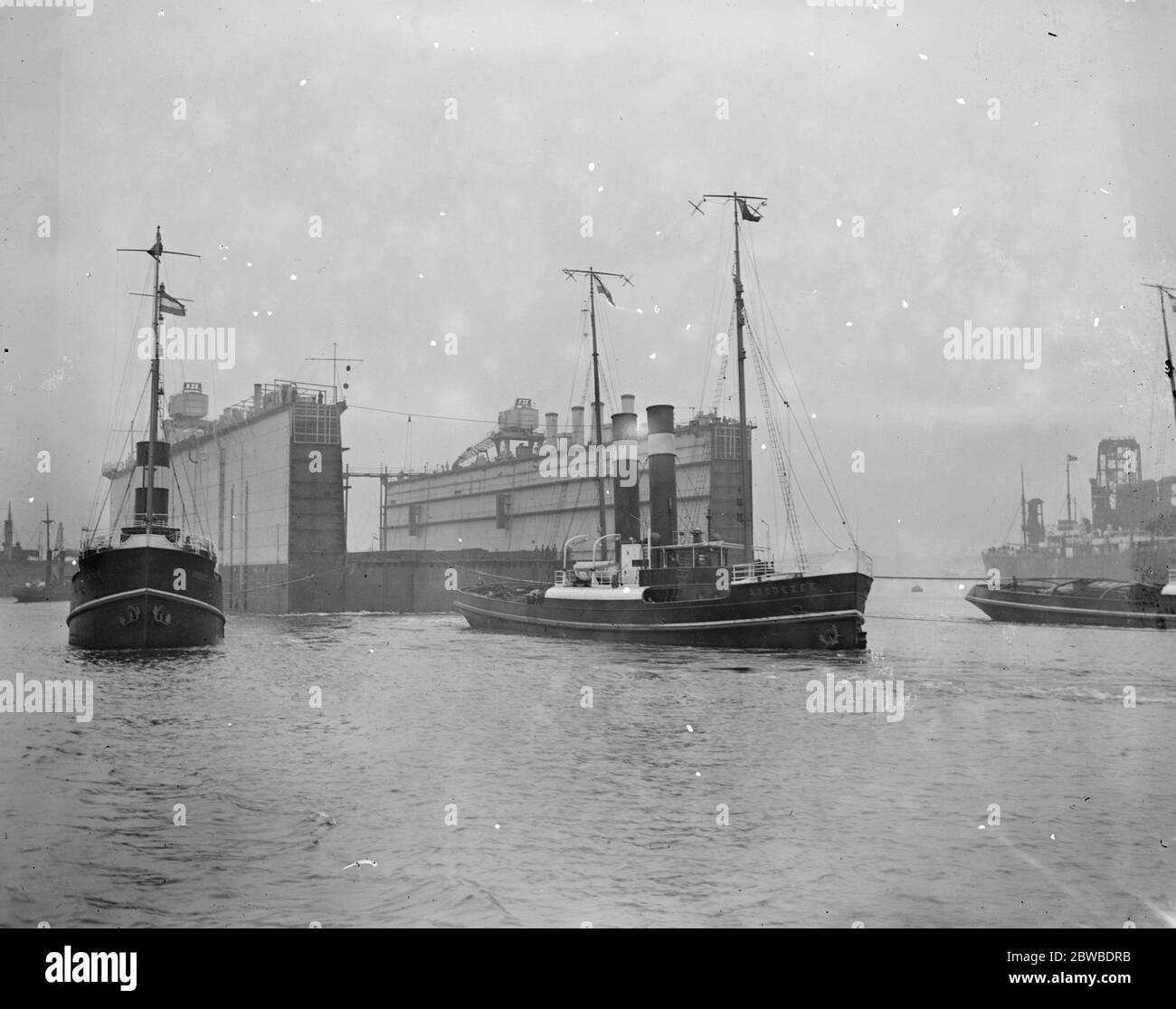 Die erste Hälfte des neuen Schwimmdocks für Singapur Verlassen der Tyne auf der rechten Seite ist der niederländische Schlepper ' Roodezee ' 21 Juni 1928 Stockfoto