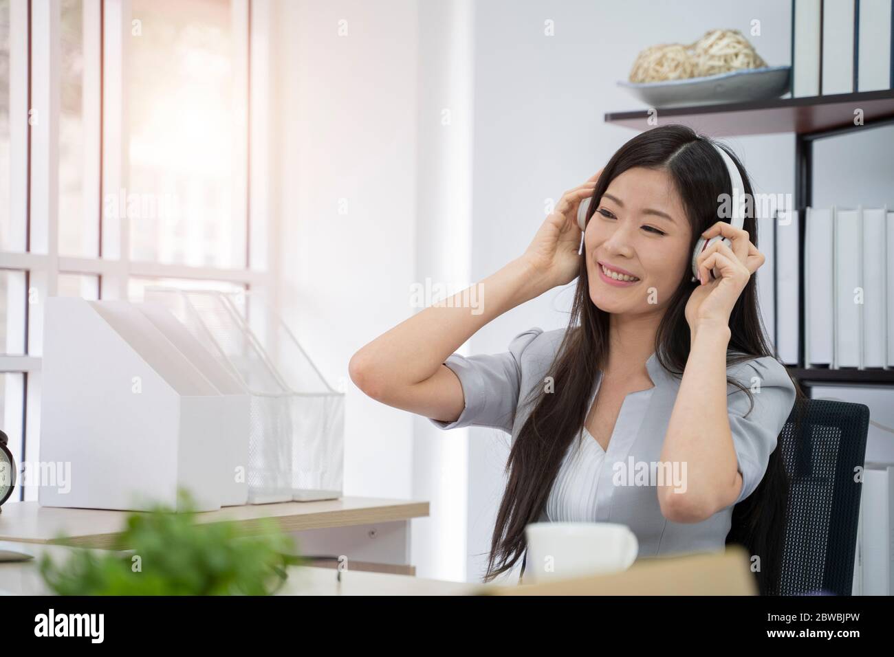 Junge Geschäftsfrau sitzt Musik hören, mit Computer. Stockfoto