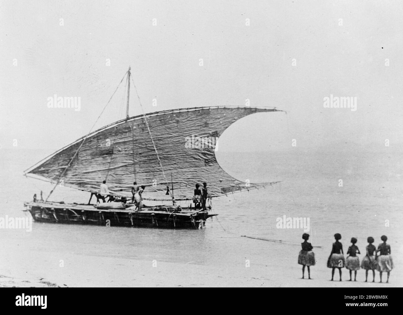 Tolle Insel zu erkunden. British Pacific Science Expedition Segel für Papua . Papua einheimischen Frauen stehen am Strand, um einen letzten Blick der abgehenden Handel Kanus zu fangen. 14 Dezember 1922 Stockfoto