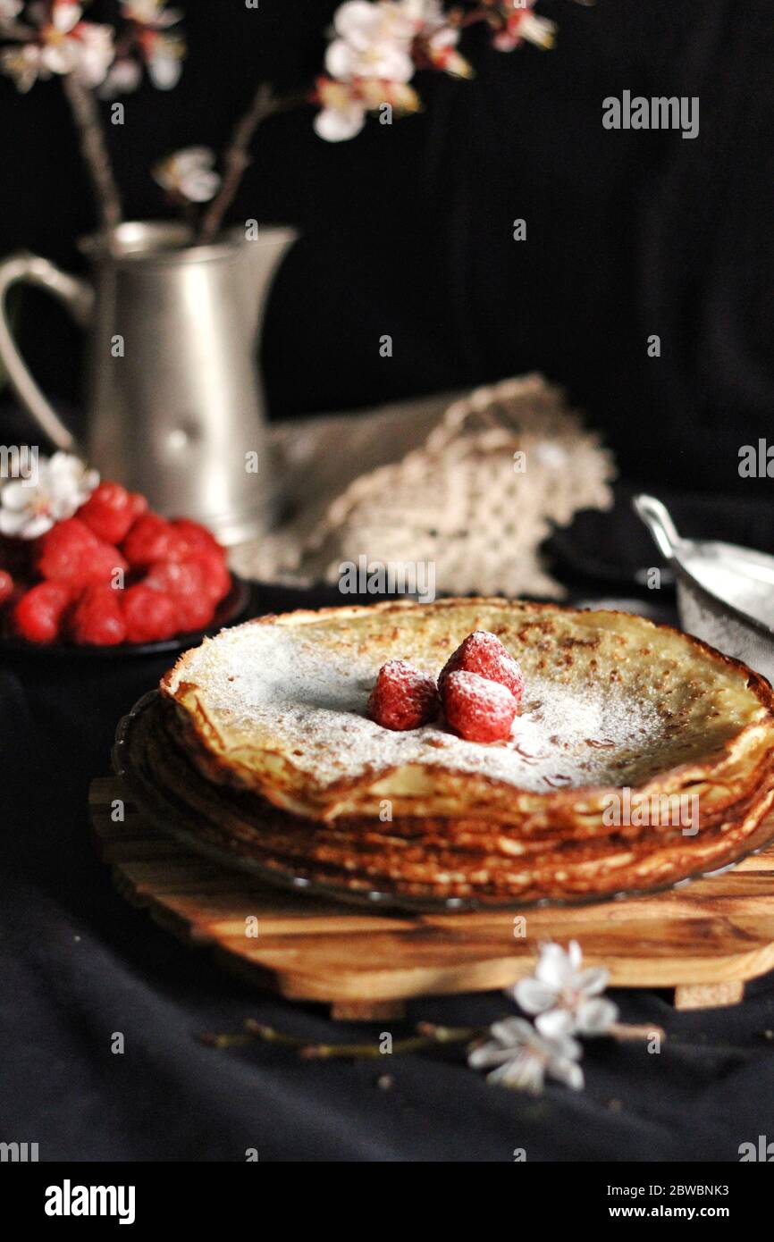 Dünne Crepes, Pfannkuchen oder Blinis auf Schiefer isoliert auf schwarzem Hintergrund, leckeres Frühstück Stockfoto
