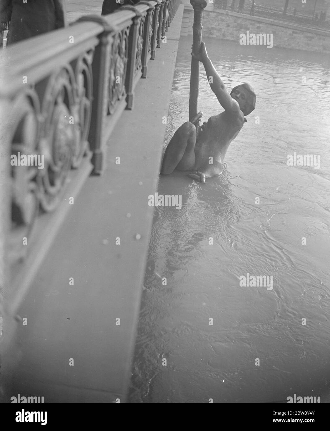 Flucht vor den Überschwemmungen . Die riesige Bronzefigur auf der Pont Mirabeau scheint angesichts der Fluten der seine angemessen gestaltet zu sein. Januar 1924 Stockfoto