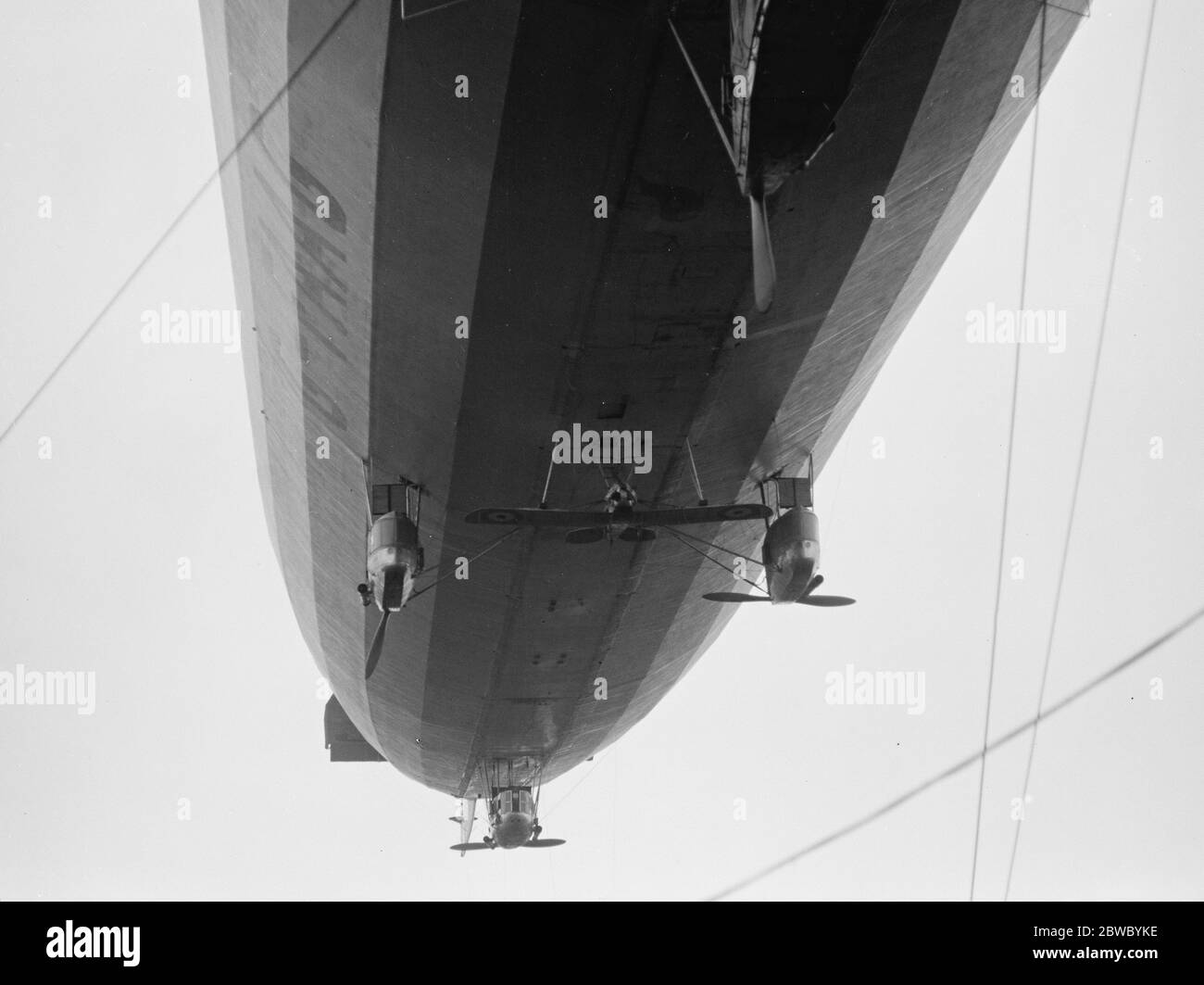 Erste Aufnahme von R 33 als einplanen Träger. Es ist nun bekannt, dass eine Luftfahrtindustrie-Entwicklung von markierter Interst in Verbindung mit der R 33 getestet wird. Das große Luftschiff wurde mit einem Gerät ausgestattet, das es ermöglicht, ein D H 53 leichter Eindecker am Luftschiff zu befestigen und von ihm im Flug abzuwerfen. 13. Oktober 1925 Stockfoto