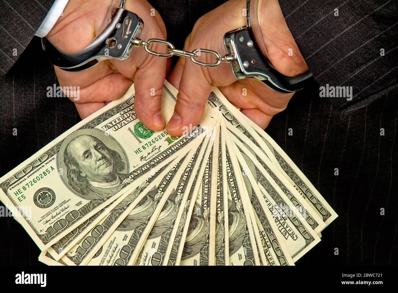 Manager mit Dollar Geldscheinen in der Hand, Handschellen, verhaftet, Schwarzgeld, Stockfoto