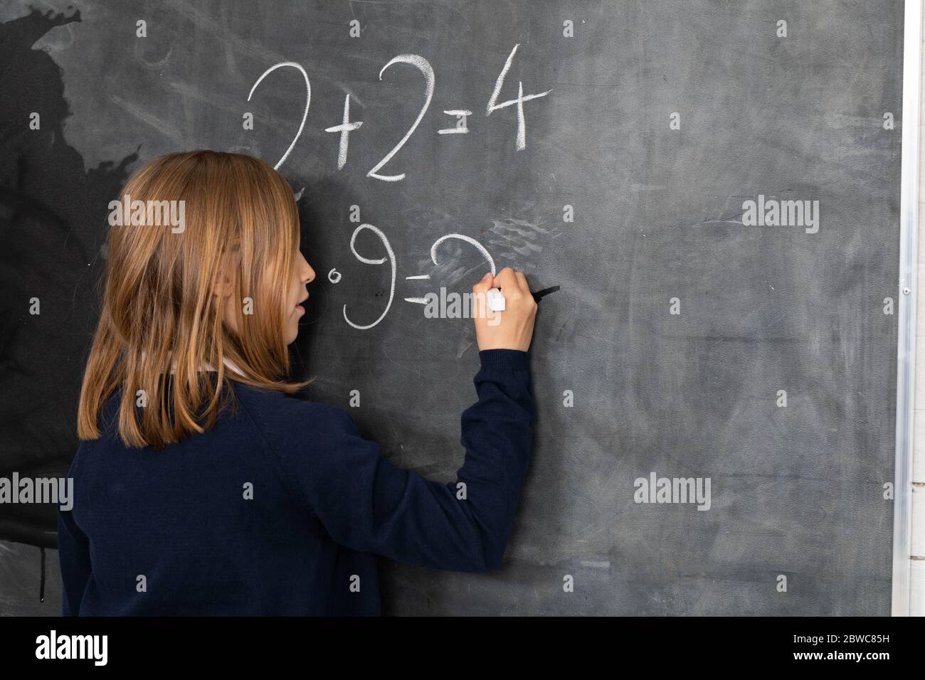 Er schreibt mit Kreide auf die Tafel. Matheproblem. Ein Mädchen an der Tafel  Stockfotografie - Alamy