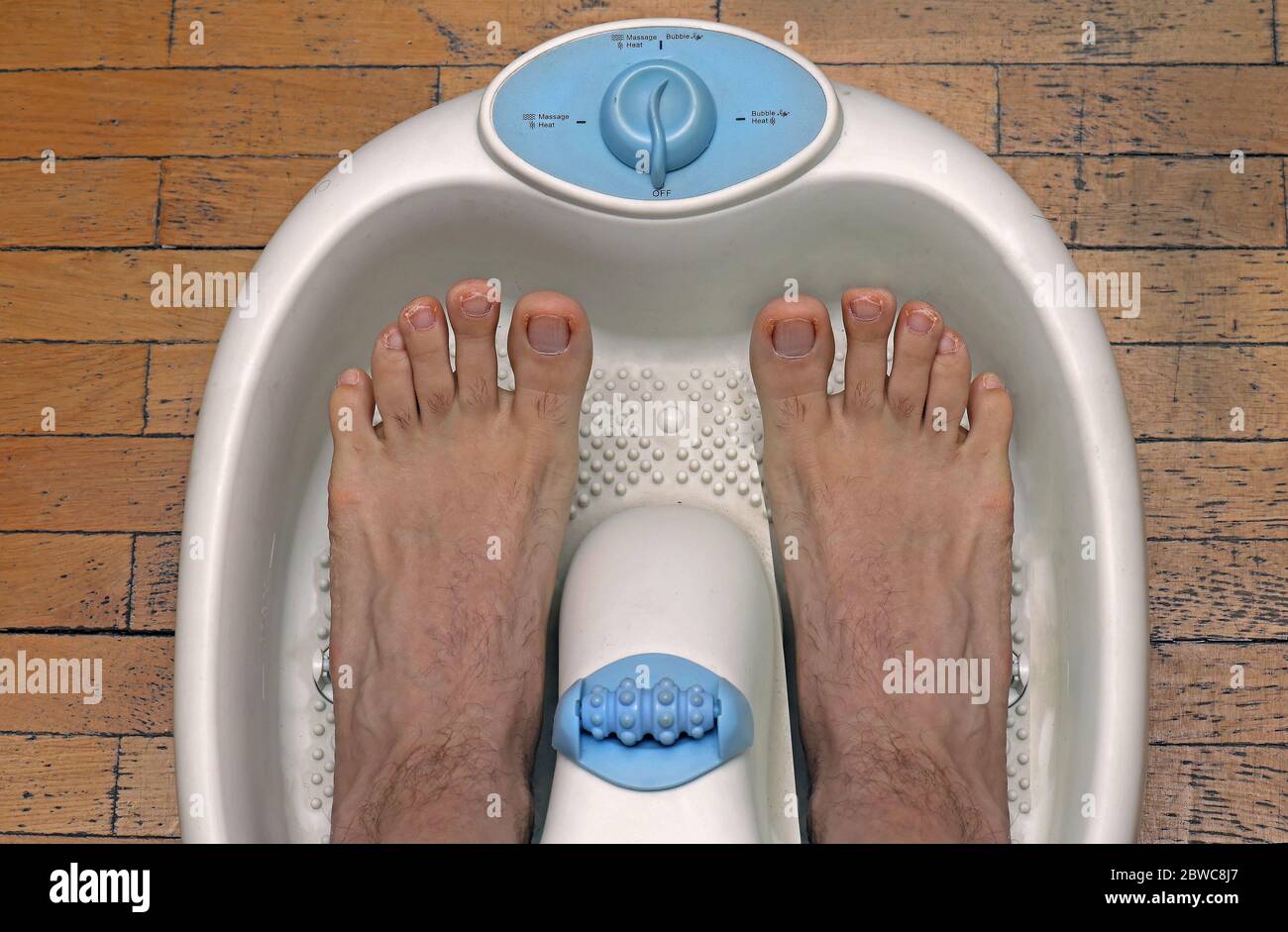 Männliche Füße in Kunststoff Pediküre Badewanne immer bereit für die Behandlung Stockfoto