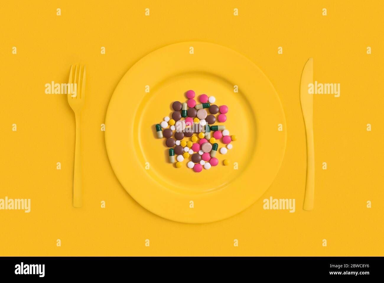 Verschiedene pharmazeutische Medikamente Pillen, Tabletten und Kapseln auf einem Teller. Auf gelbem Hintergrund Stockfoto