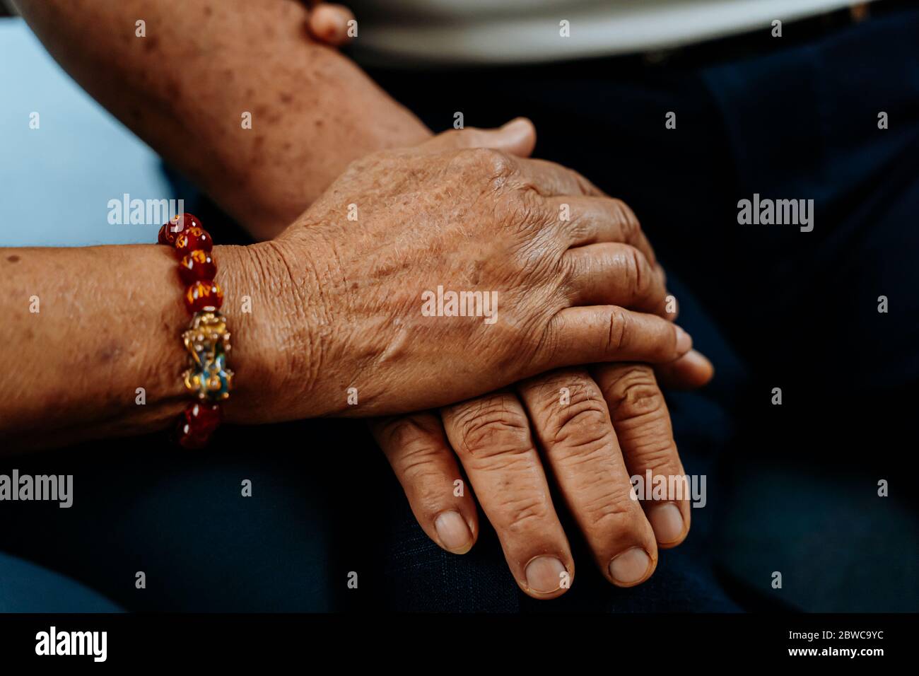 Nahaufnahme der Hand einer älteren Frau, die die Hände eines alten Mannes hält. Romantische Liebe dauerhaft für immer Konzept Stockfoto