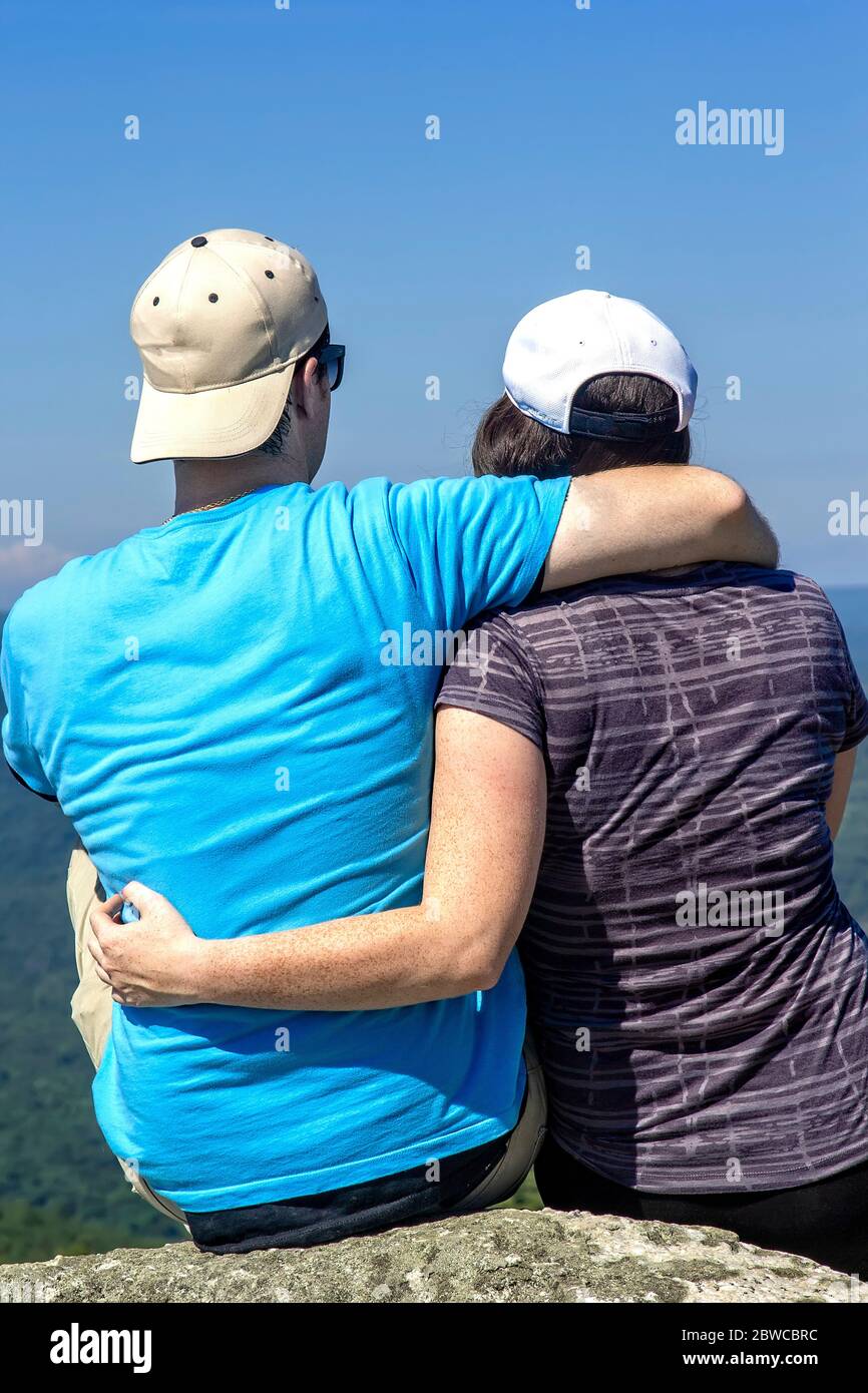 New Paltz, NY - 22. Juni 2014: Ein junges Paar umarmt und genießt den Blick auf das Hudson Valley auf einem Berggipfel im Upstate New York. Stockfoto