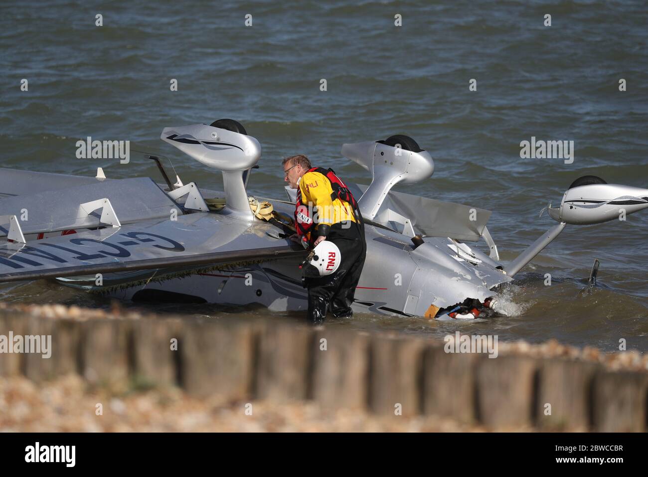 Die Trümmer leichter Flugzeuge wuschen am Strand, nachdem sie in das Meer nahe Calshot Spit stürzten. Zwei Menschen wurden aus dem Flugzeug gerettet. Stockfoto