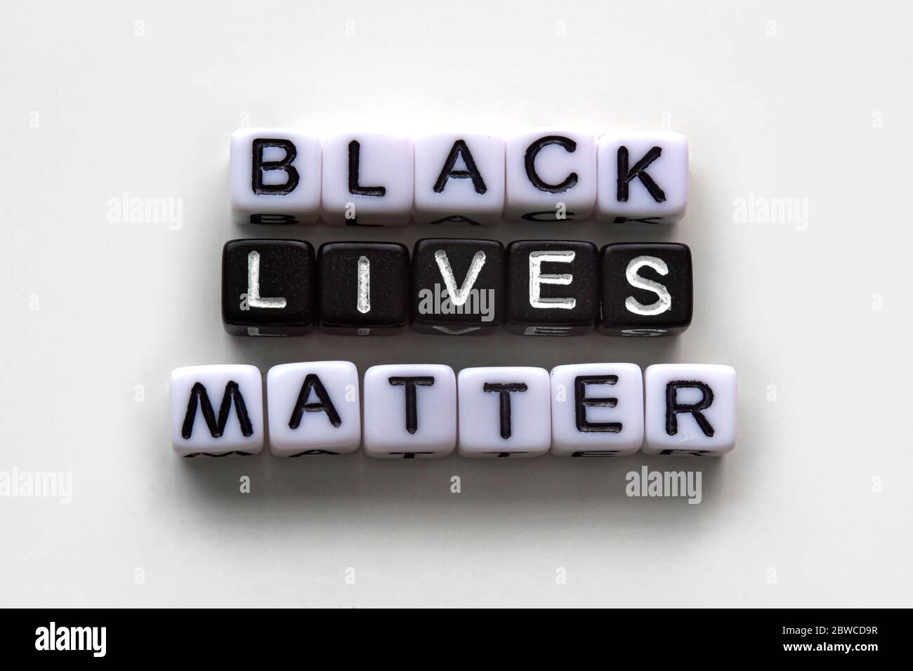 Schwarz lebt Materie, Nachrichtentext mit schwarzen und weißen Würfeln auf weißem Hintergrund Stockfoto