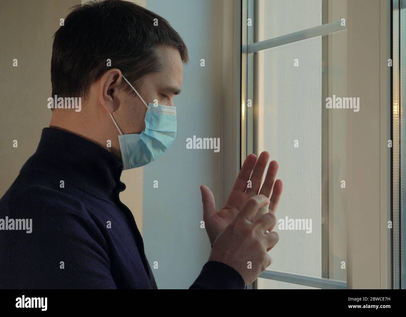 Der Mensch betritt das Haus mit einer medizinischen Maske. Pandemie. Stockfoto