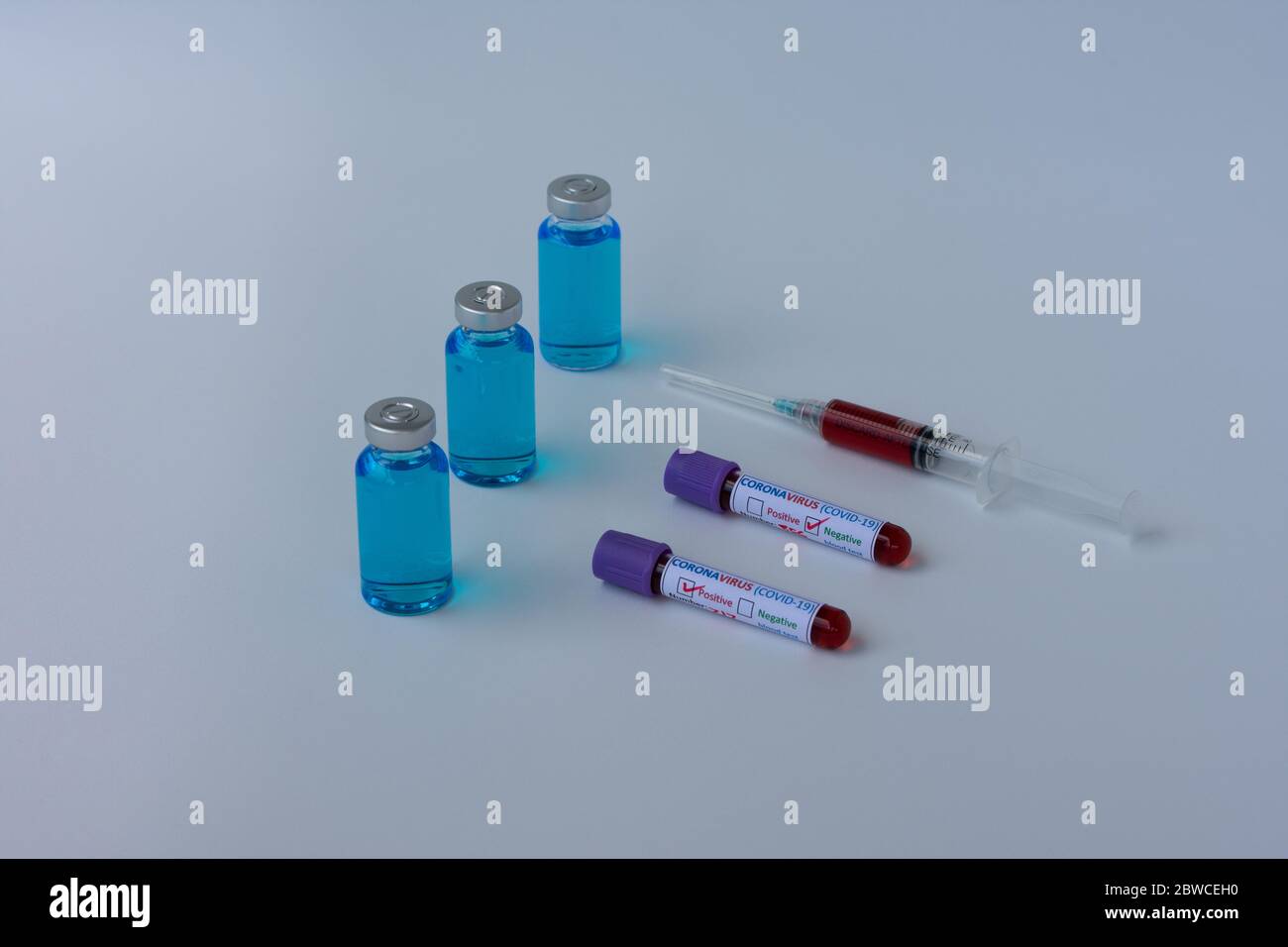 Impfstofffläschchen, Reagenzgläser und eine Spritze, die eine Blutprobe enthält, ein Reagenzglas für die Coronavirus-Analyse (COVID-19). Stockfoto