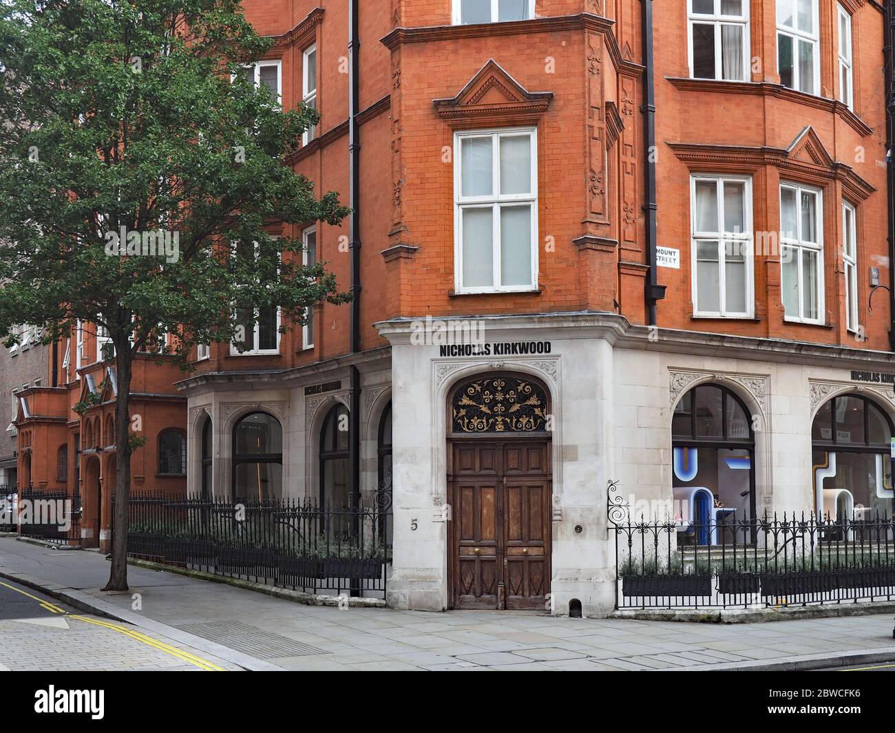 Ein altmodisches Apartmentgebäude im Londoner Stadtteil Mayfair mit einem Geschäft im Erdgeschoss Stockfoto