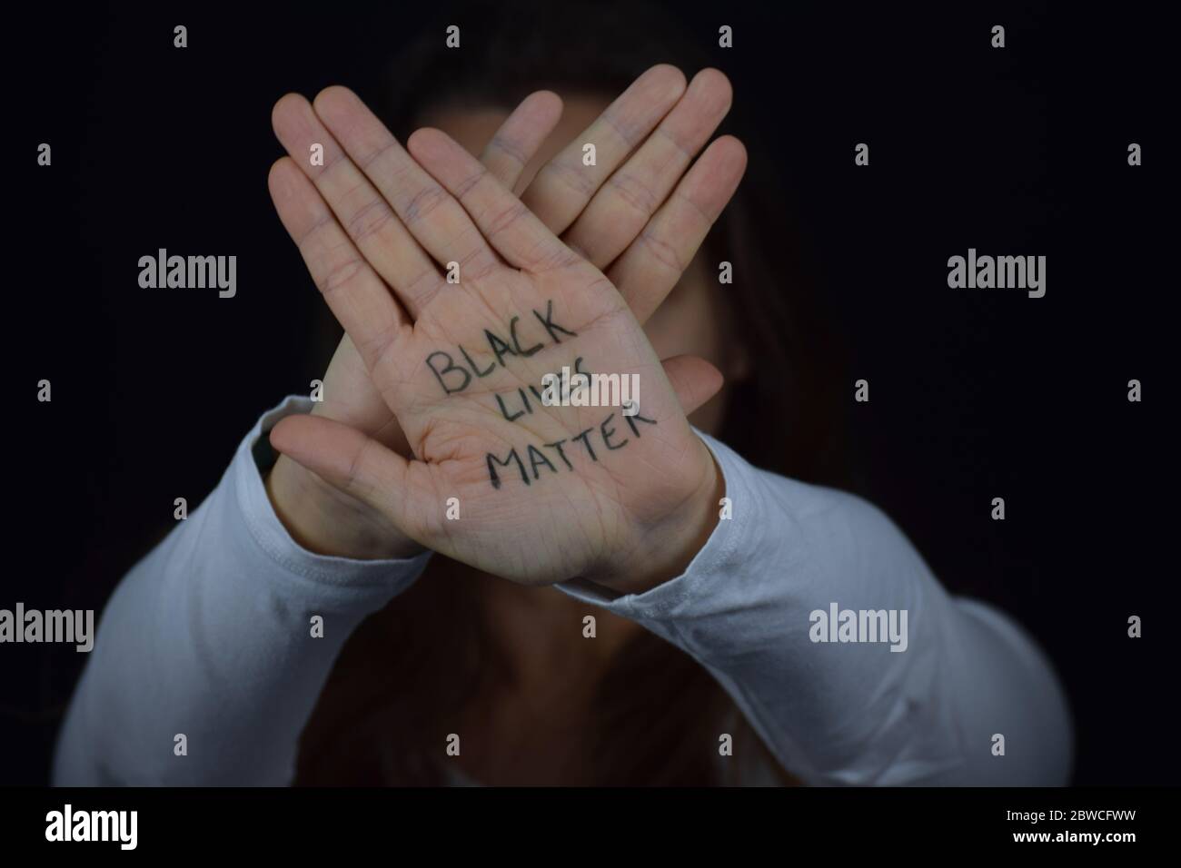 Kaukasische Frau mit zwei Händen gekreuzt mit Worten Black Lives Matter. Weiße Leute, die sich für schwarze Gemeinschaften engagieren. Friedlicher Protest. Stockfoto