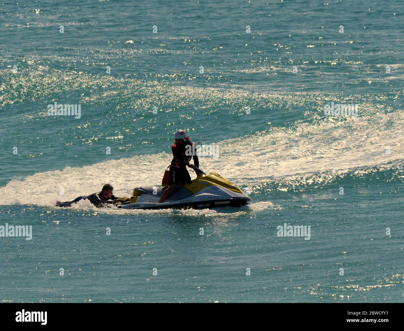 RNLI Rettungsschwimmer retten Surfer am fistral Beach einen Tag nach der Wiederaufnahme des Services am Fistral Beach Cornwall UK Stockfoto