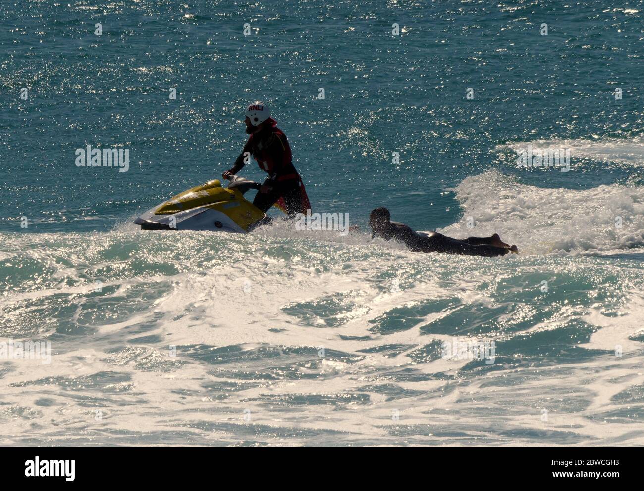 RNLI Rettungsschwimmer retten Surfer am fistral Beach einen Tag nach der Wiederaufnahme des Services am Fistral Beach Cornwall UK Stockfoto
