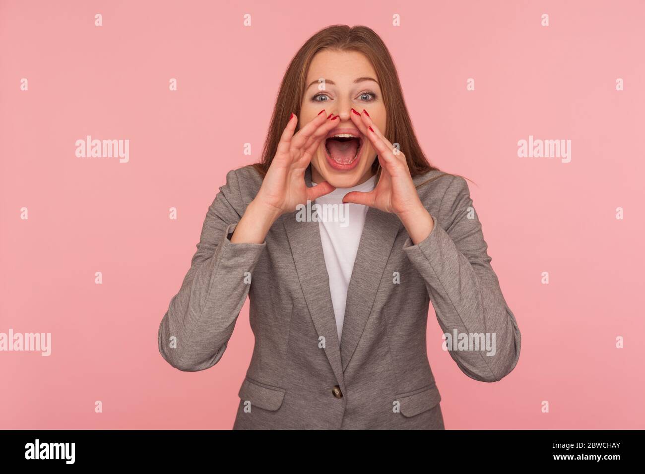 Ankündigung! Porträt der jungen Frau in Business-Anzug hält die Hände um den Mund wie Megaphon, laut schreien, schlechte Nachrichten schreien, Aufmerksamkeit auf im Stockfoto