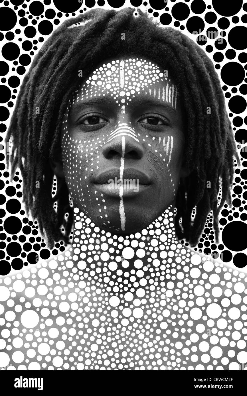 Porträt eines jungen afrikaners mit Dreadlocks und traditioneller Gesichtsfarbe, die direkt in die Kamera schauen Stockfoto