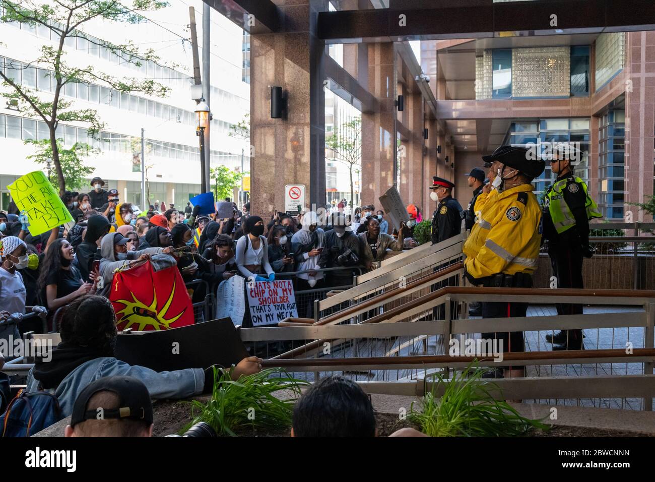 Demonstranten schreien, während Polizisten ruhig bei einem "Not Another Black Life"-Protest nach dem Tod von Regis Korchinski-Paquet in Toronto stehen. Stockfoto