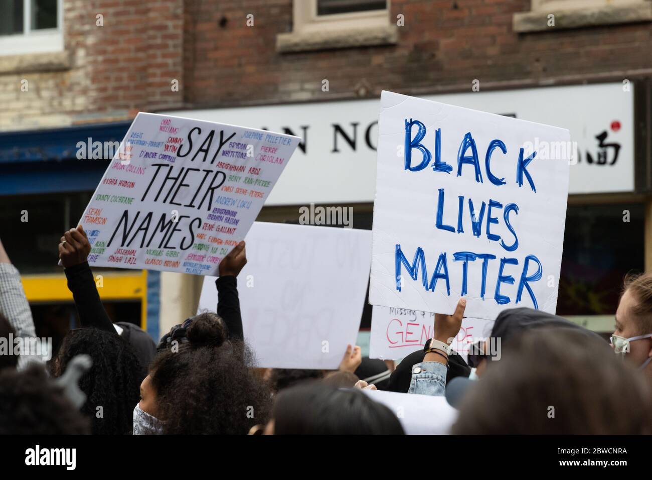 Demonstranten marschieren durch die Innenstadt von Toronto, um gegen die Strafverfolgung als Reaktion auf Regis Korchinski-Paquet und George Floyds Tod zu protestieren. Stockfoto