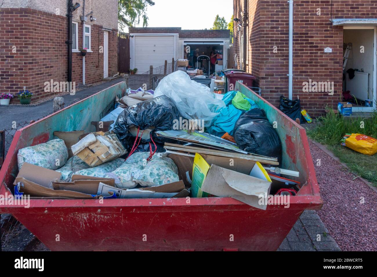 Ein sprung auf der Auffahrt eines Wohnhauses voller Müll, da der Hausbesitzer einen Klon aus dem verroteten Müll hat. Stockfoto