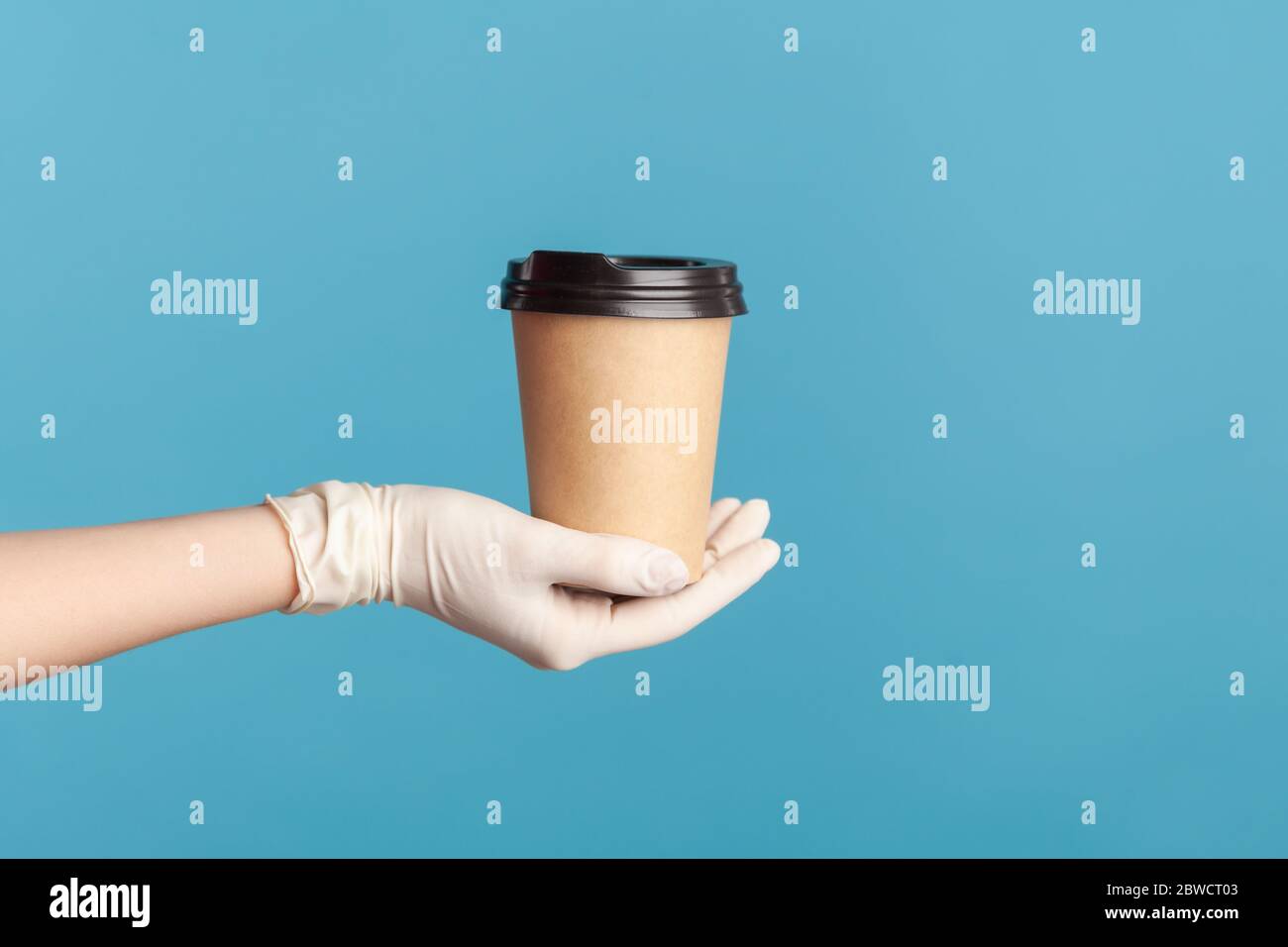 Profil Seitenansicht Nahaufnahme der menschlichen Hand in weißen chirurgischen Handschuhen halten und zeigen Tasse heißen Take away Becher Getränk in der Hand. Indoor, Studio-Aufnahme, isola Stockfoto