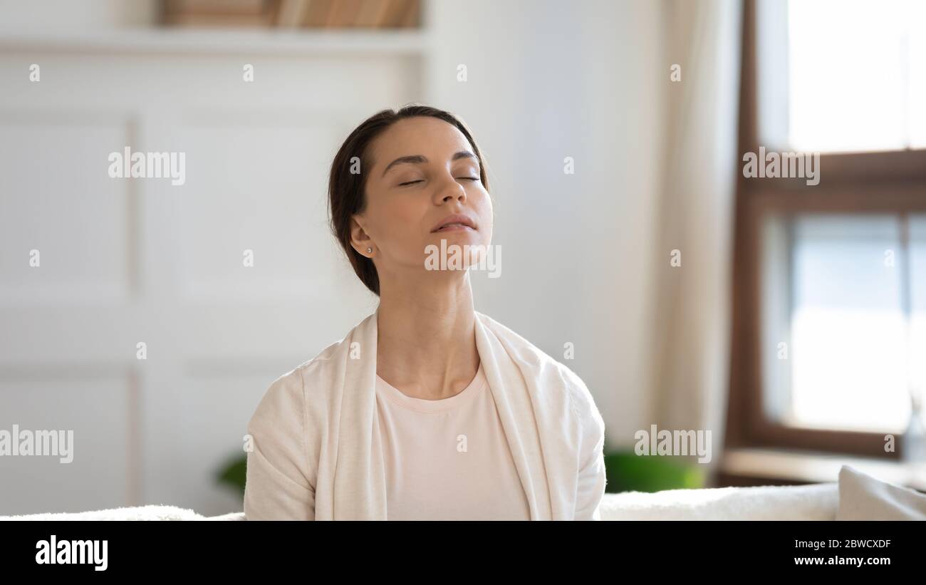 Junge Frau zu Hause entspannen atmen frische Luft Stockfoto