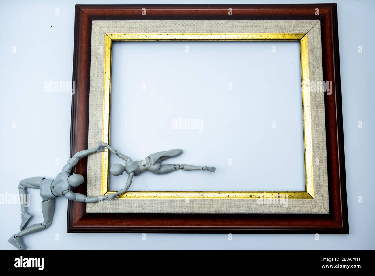 Mini Figuren versuchen, aus dem Rahmen zu entkommen, Komfort-Zone-Konzept auf weißem Hintergrund, isoliert Stockfoto