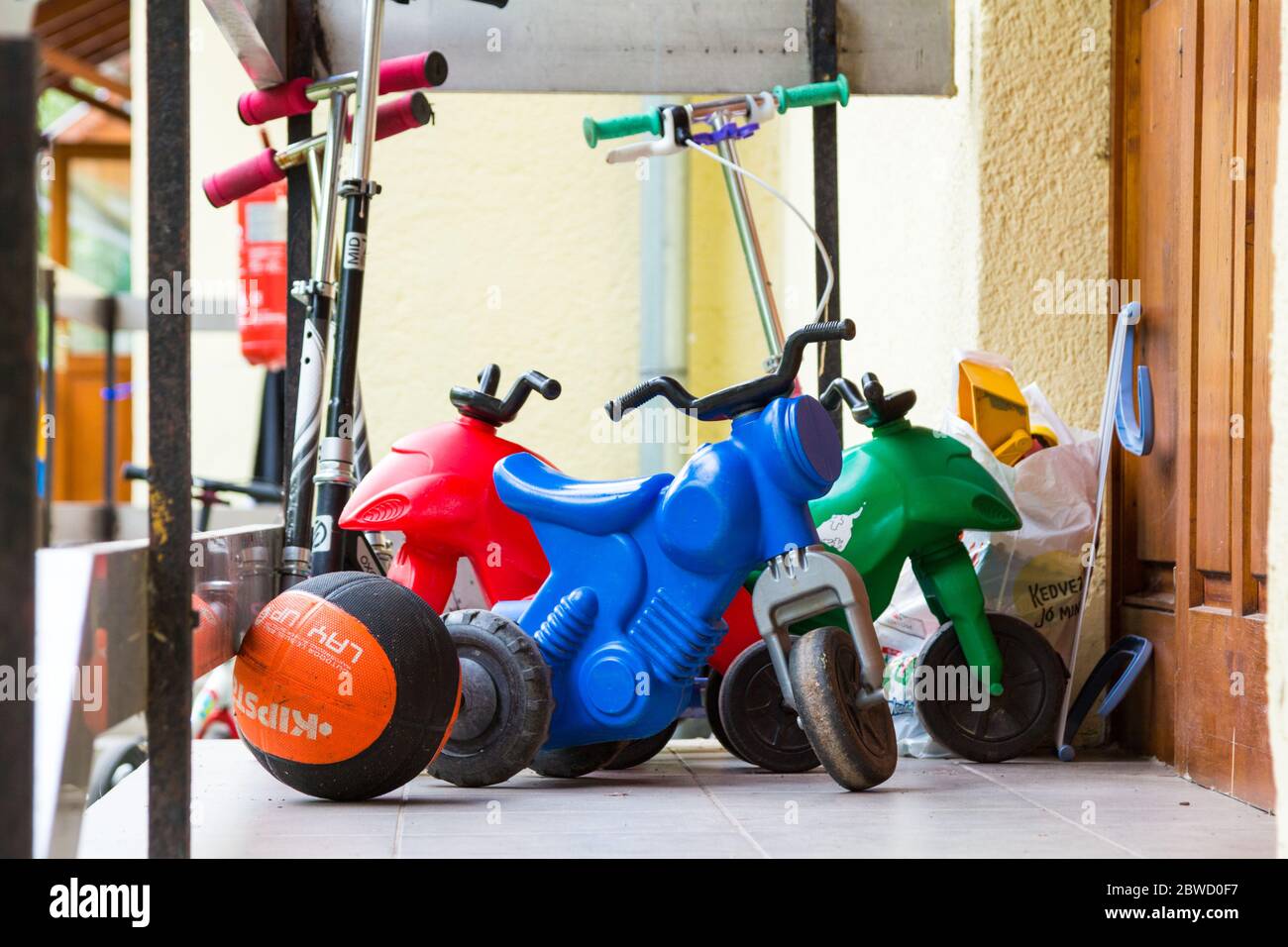 Spielzeug, Ball, Roller, Kunststoff-Motorräder vor der Tür des Sommercamps Bungalow, Balaton, Ungarn Stockfoto