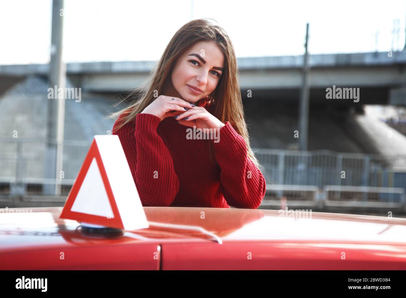 Junge schöne glückliche Frau posiert in der Nähe Training Auto Stockfoto