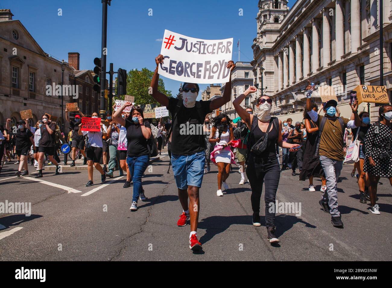 Aktivisten marschieren entlang Whitehall, während sie Plakate während der George Floyd Demonstration halten. Tausende kamen zu dem Protest zusammen, trotz der anhaltenden Bedenken über die mögliche Verbreitung des Coronavirus und der anhaltenden Forderungen der Behörden nach Einhaltung der Richtlinien für soziale Distanzierung. Floyd, ein schwarzer Mann, starb als weißer Polizist, Derek Chauvin, kniete auf seinem Hals während einer Verhaftung in der US-Stadt Minneapolis am 25. Mai. Floyds Tod, der an den Würgegriff des 2014 von Polizisten in New York überhandverlegten Eric Garner erinnert, hat die Bewegung 'Black Lives Matter' agai wieder entfacht Stockfoto