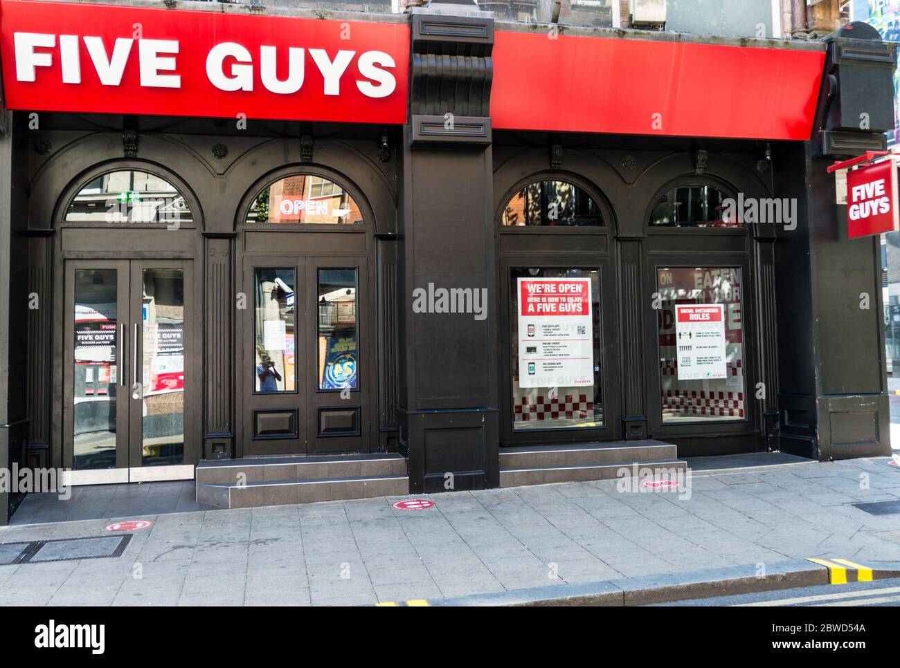 Fünf Jungs Fast-Food-Restaurant Betrieb nehmen nur mit strengen sozialen Distanzierungsregeln Stockfoto