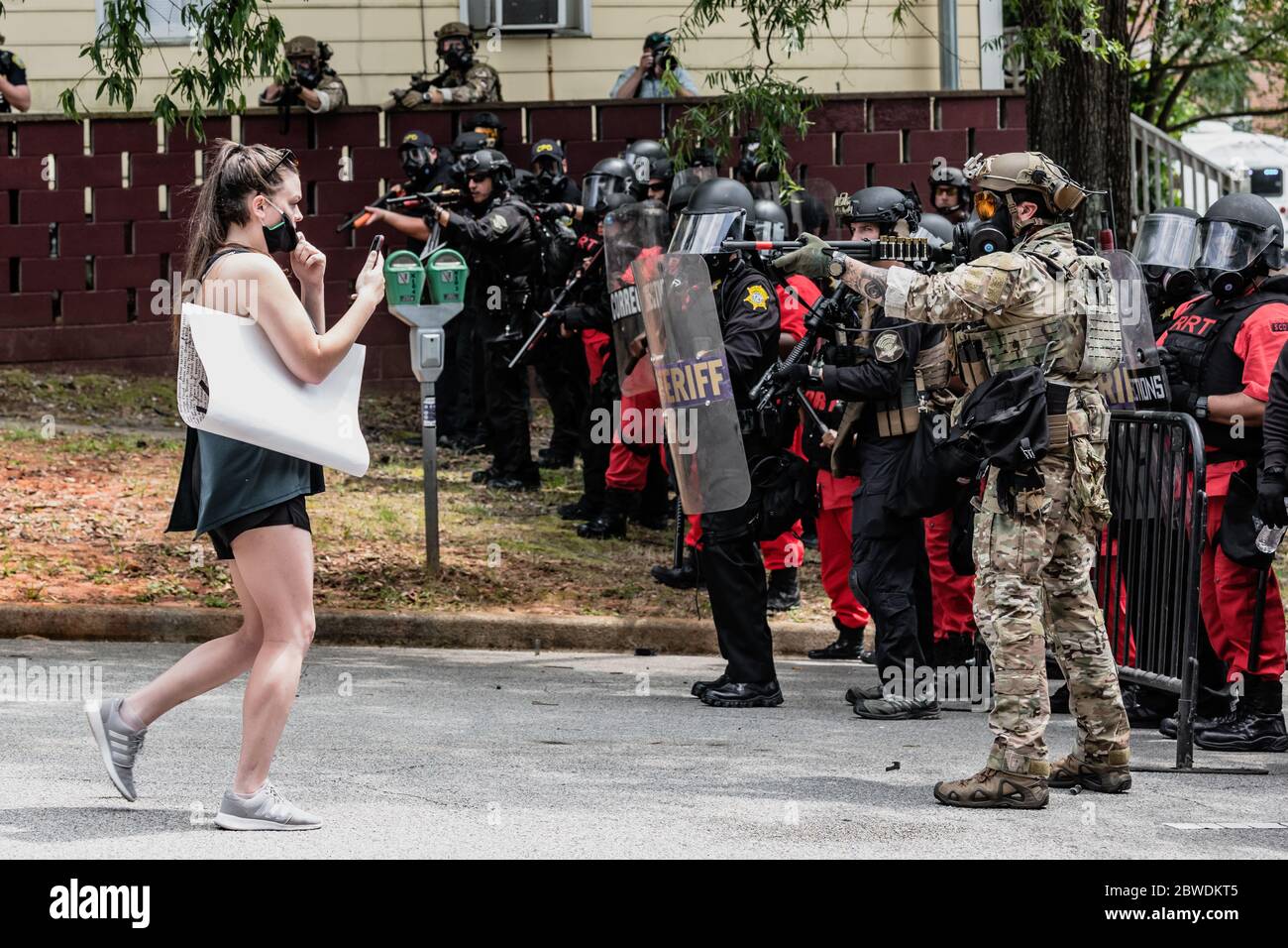 Columbia, South Carolina - USA - 30. Mai 2020: Eine unbewaffnete Protestierende hat eine Waffe auf sie gezogen, während sie versucht, zum Columbia Police Department zu marschieren, um gegen die Brutalität der Polizei gegen Minderheiten und den jüngsten Tod von George Floyd zu protestieren. Die Präsenz der Strafverfolgungsbehörden in der Stadt war aufgrund von Unruhen und Unruhen, die am Vortag passiert schwer. George Floyd wurde am 25. Mai 2020 in Minneapolis, MN, während in Polizeigewahrsam getötet. Zuschauer sahen zu, wie Floyd seine Atemschwierigkeiten ausdrückte, während Officer Derek Chauvin neun Minuten lang auf seinem Hals kniete. Sein Tod hat na ausgelöst Stockfoto