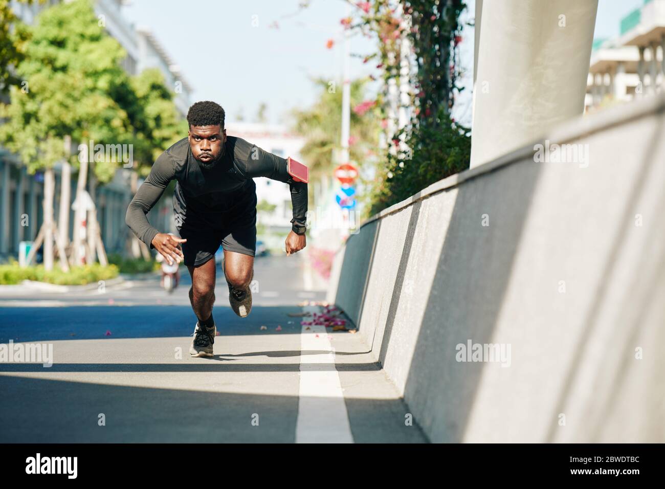 Gut aussehende Passform ernster Sportler Sprint auf der Straße, wenn die Vorbereitung für Triathlon Stockfoto