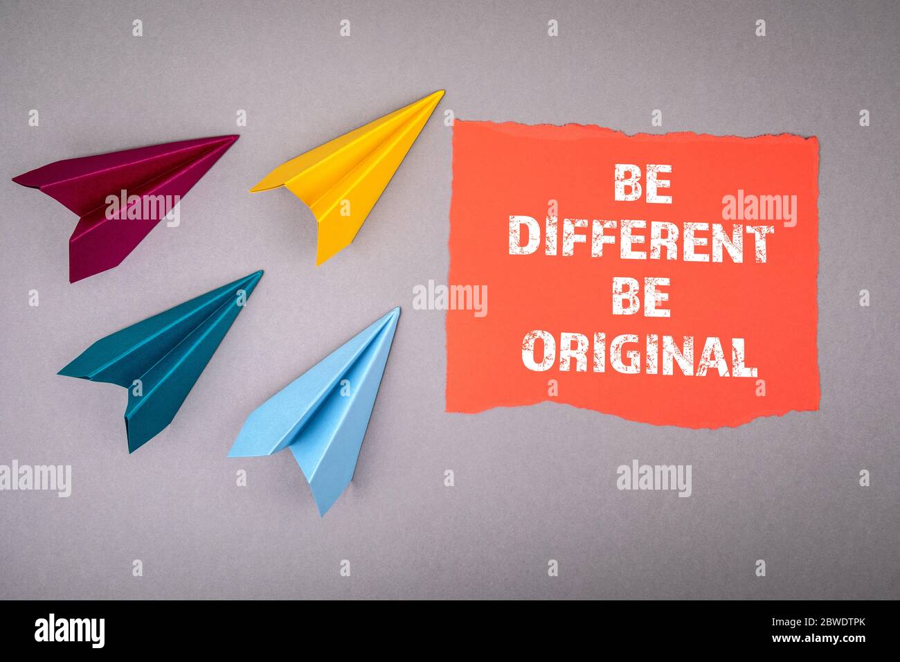 SEIEN SIE ANDERS und ORIGINELLES Konzept. Text auf Notizblatt, Papierflächen um, Symbol für das Erreichen von Zielen, Streben nach oben Stockfoto