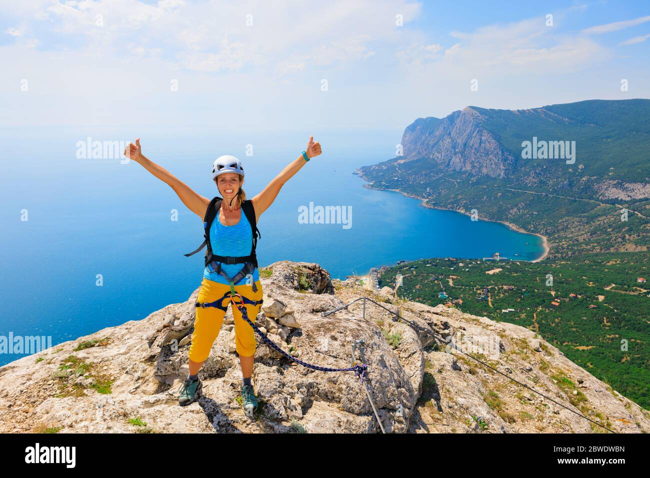 Glückliche junge Frau stehen auf Mount-Top. Tolle Meereslandschaft. Familienreise Abenteuer, Wanderaktivität. Klettersteig mit Kindern, Natur erkunden Stockfoto