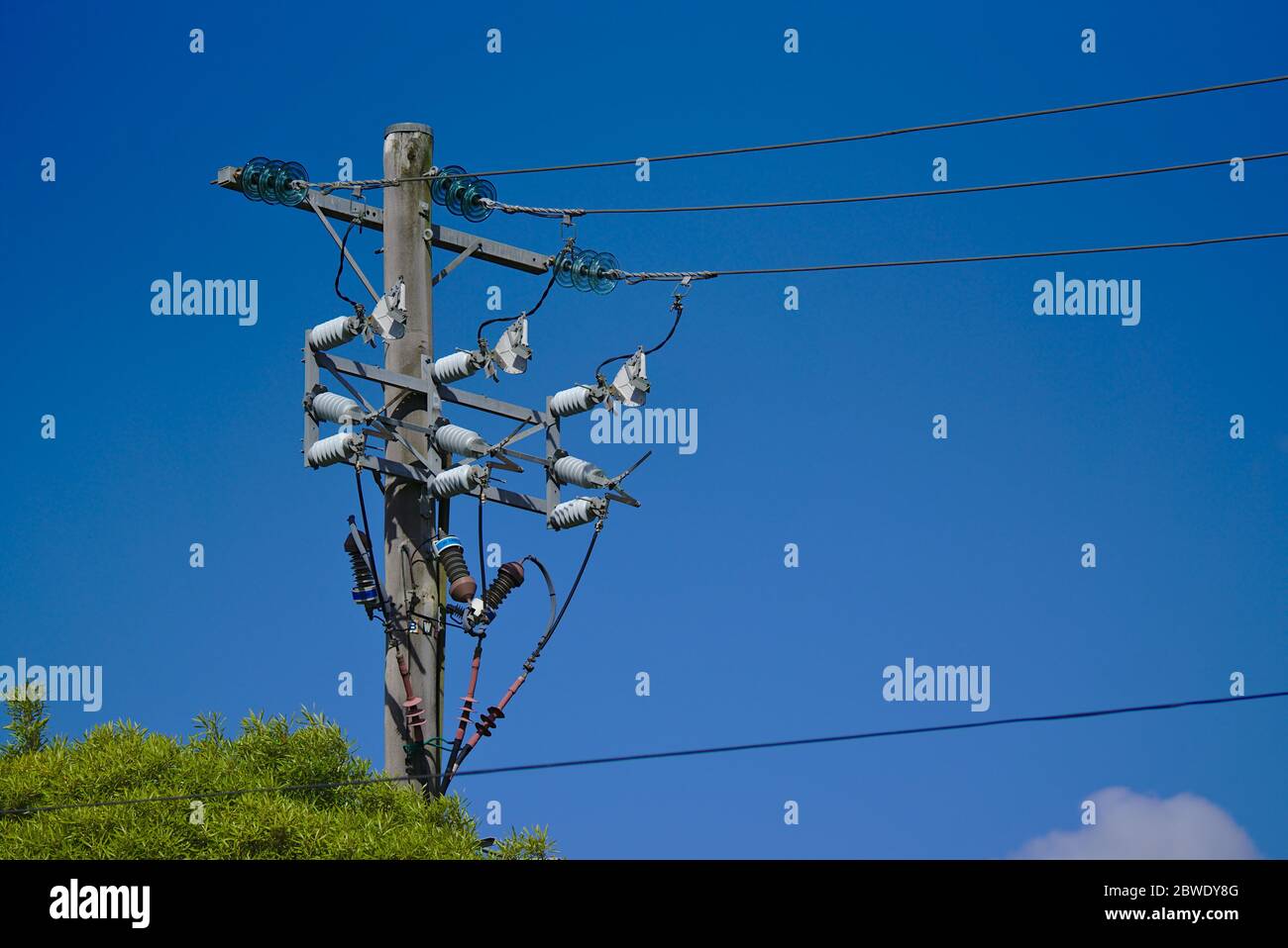 Fernansicht der Hochspannungsleitungen elektrische Post mit blauem Himmel Hintergrund Stockfoto