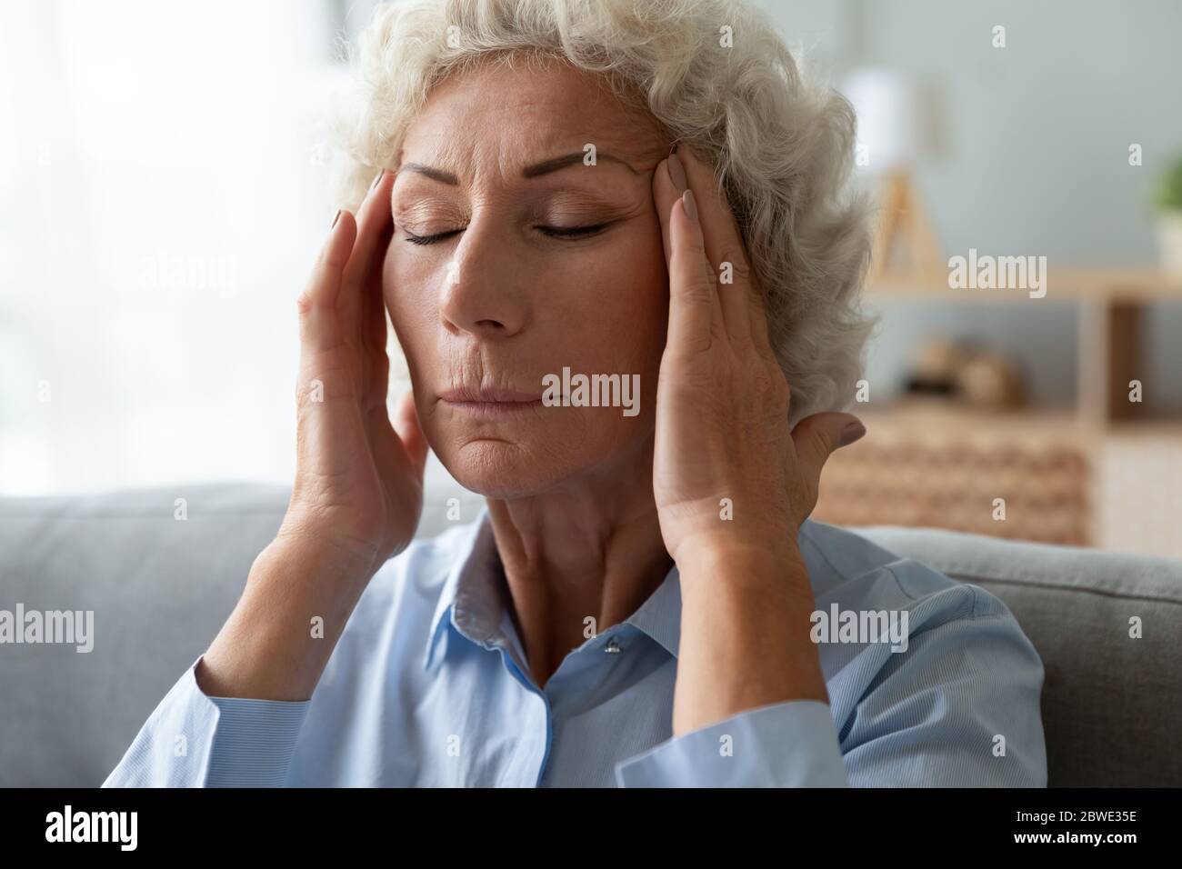 Nahaufnahme Ältere Frau Massage Tempel reduziert intensive Kopfschmerzen Stockfoto