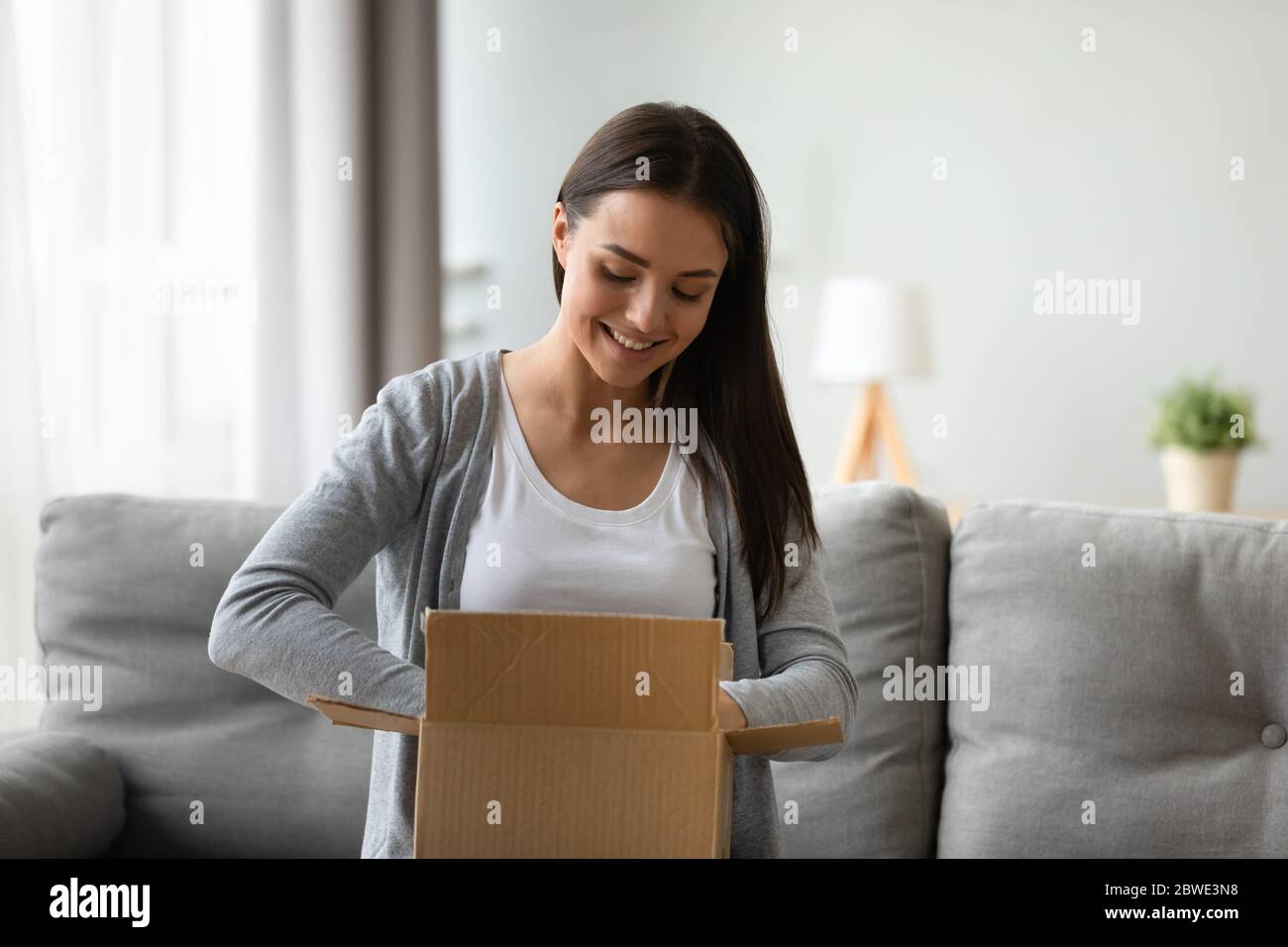 Zufriedene Frau Auspacken Box lächelnd genießen schnelle Lieferung Service Stockfoto