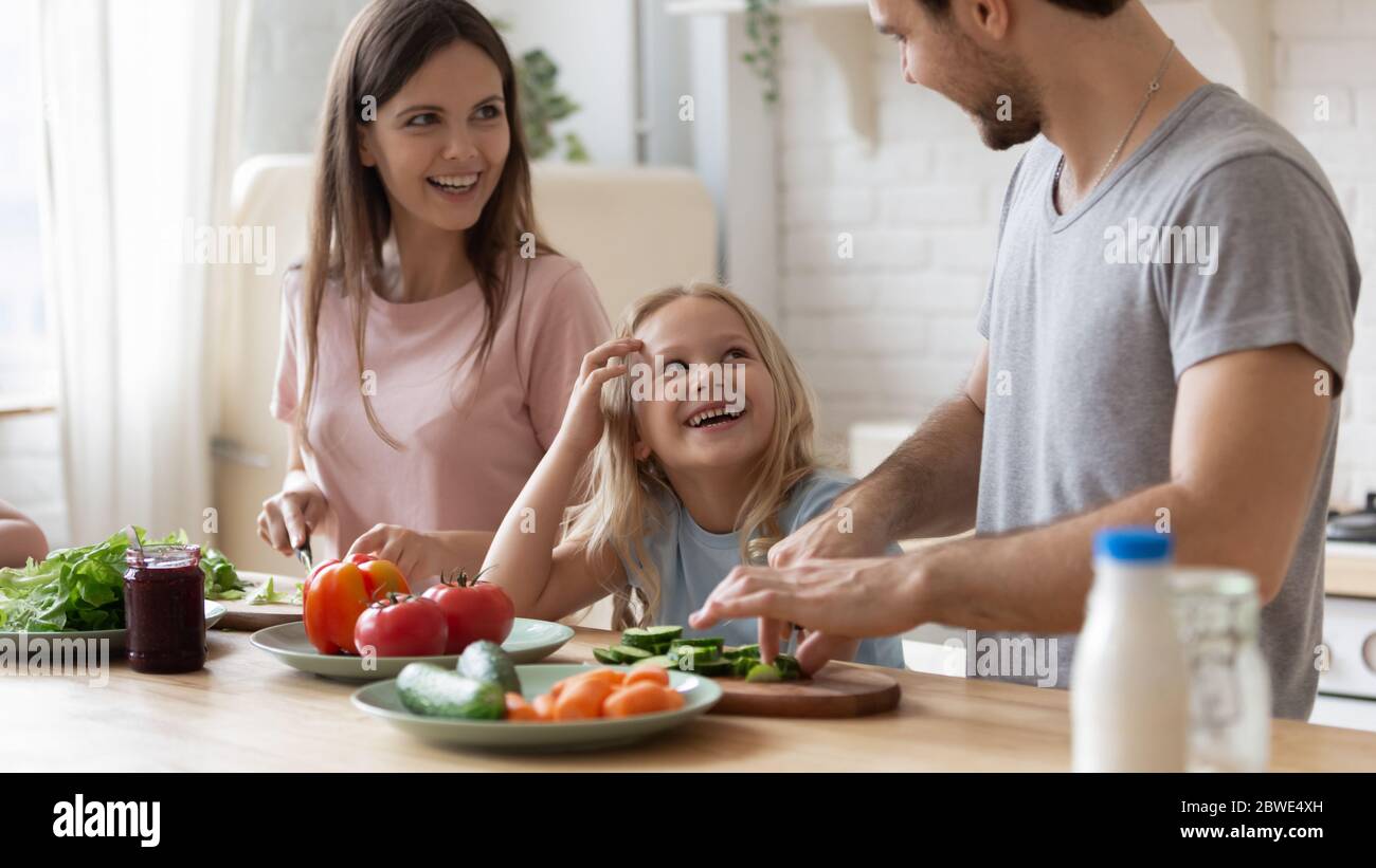 Glückliche junge Familie mit Kindern Kochen gesunde Lebensmittel zu Hause Stockfoto