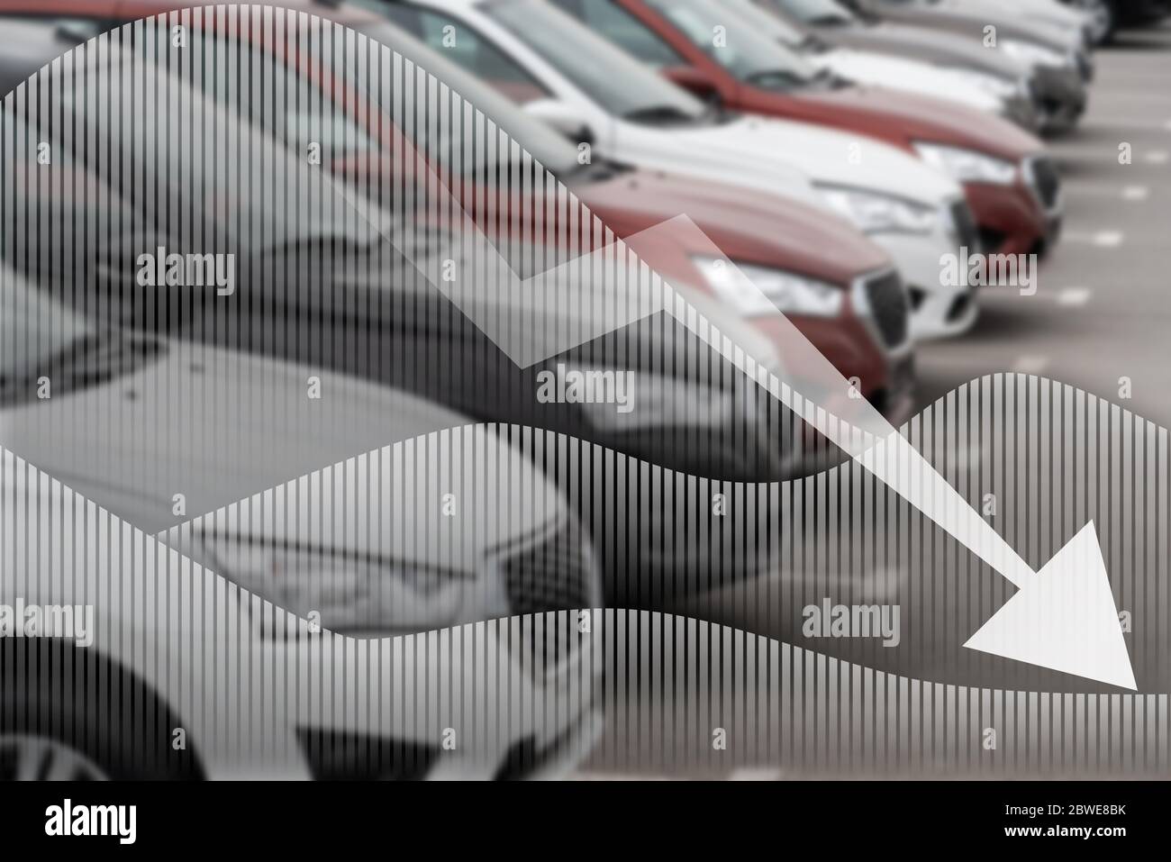 Pfeil nach unten auf einem Hintergrund von Autos. Ein Symbol der Krise in der Automobilindustrie Stockfoto