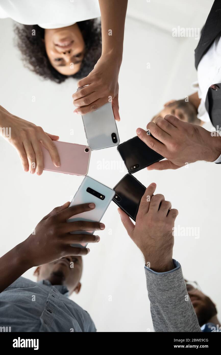 Nahaufnahme von verschiedenen Menschen mit Telefonen, im Kreis stehend Stockfoto