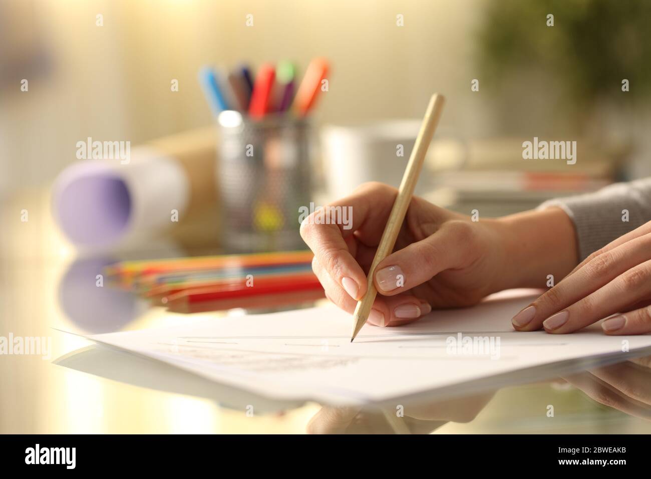 Nahaufnahme Seitenansicht der Designerin Frau Hände skizzieren Zeichnung mit Bleistift auf dem Schreibtisch zu Hause Stockfoto