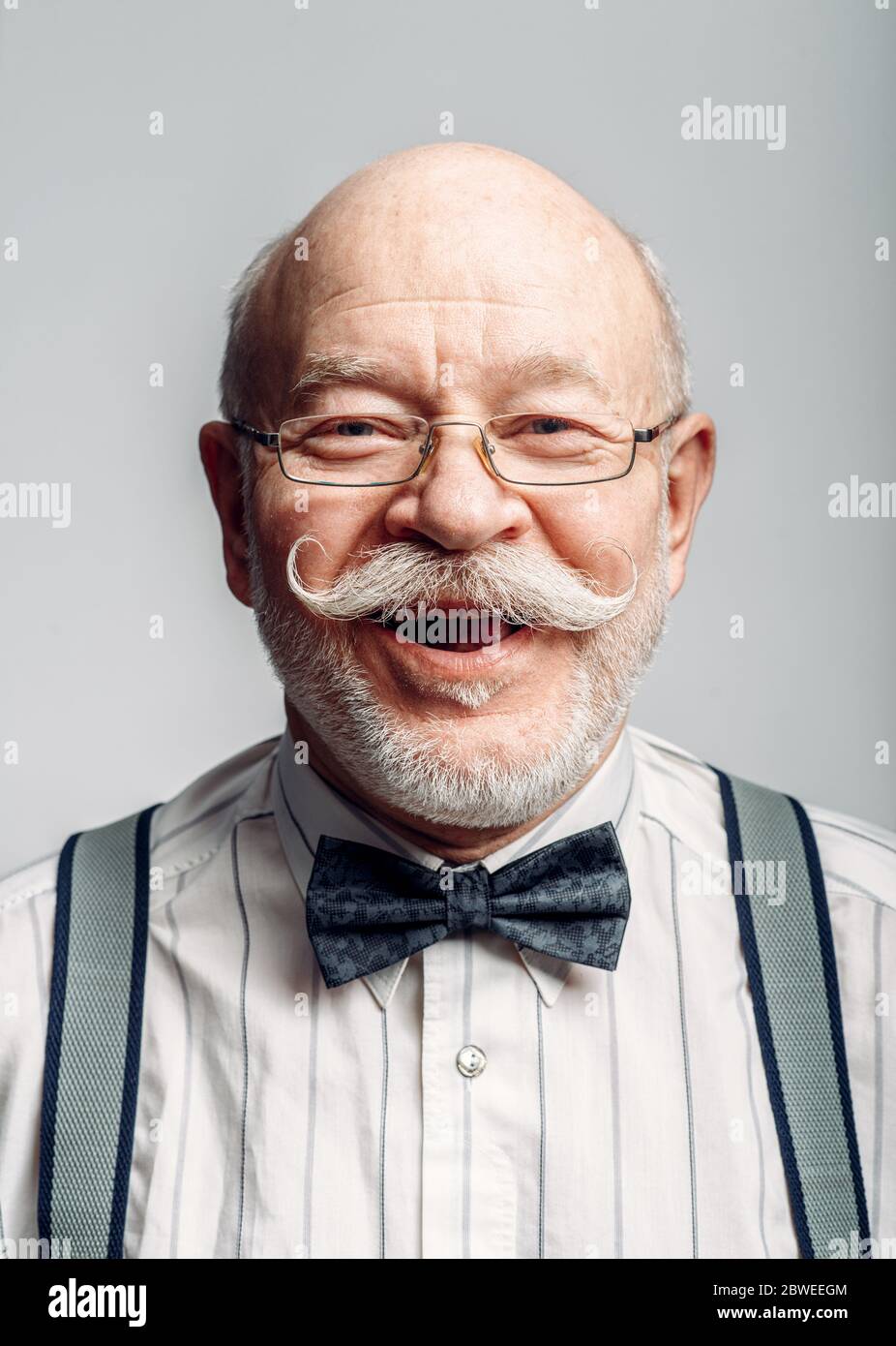 Lächelnder älterer Mann in Fliege und Brille Stockfoto