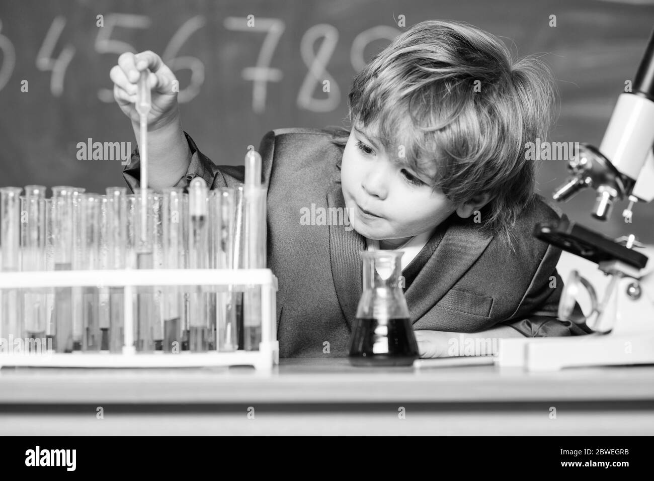 Schule Bildung. Biologische Moleküle erkunden. Kleinkind genius Baby. Junge in der Nähe von Mikroskop und Reagenzgläser in der Schule Klassenzimmer. Technik und Wissenschaft Konzept. Kid studiere Biologie und Chemie in der Schule. Stockfoto