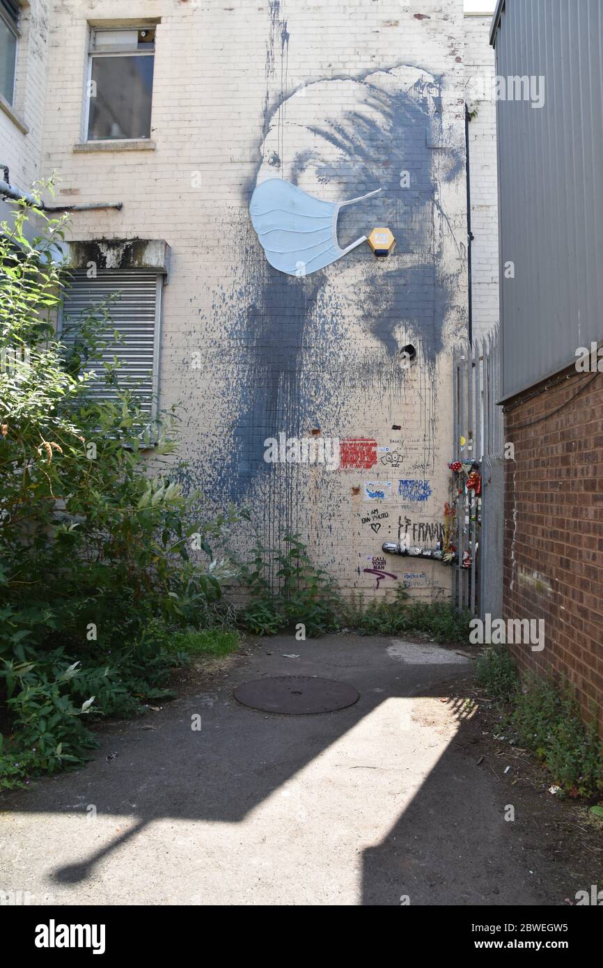 Banksy Graffiti das Mädchen mit dem durchbohrten Trommelfell mit blauer Gesichtsmaske (Covid-19). Albion Dockyard, Hanover Place, Bristol Stockfoto