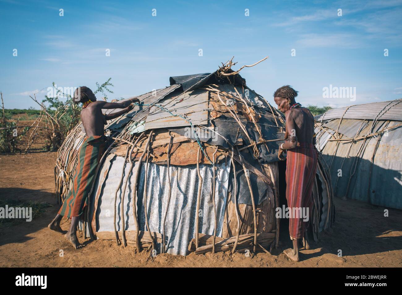 Omorate, Omo Valley, Äthiopien - 11. Mai 2019: Frau vom afrikanischen Stamm Dasanesh repariert Hütte. Daasanach sind die ethnischen Gruppen der Cushiten, die in E leben Stockfoto