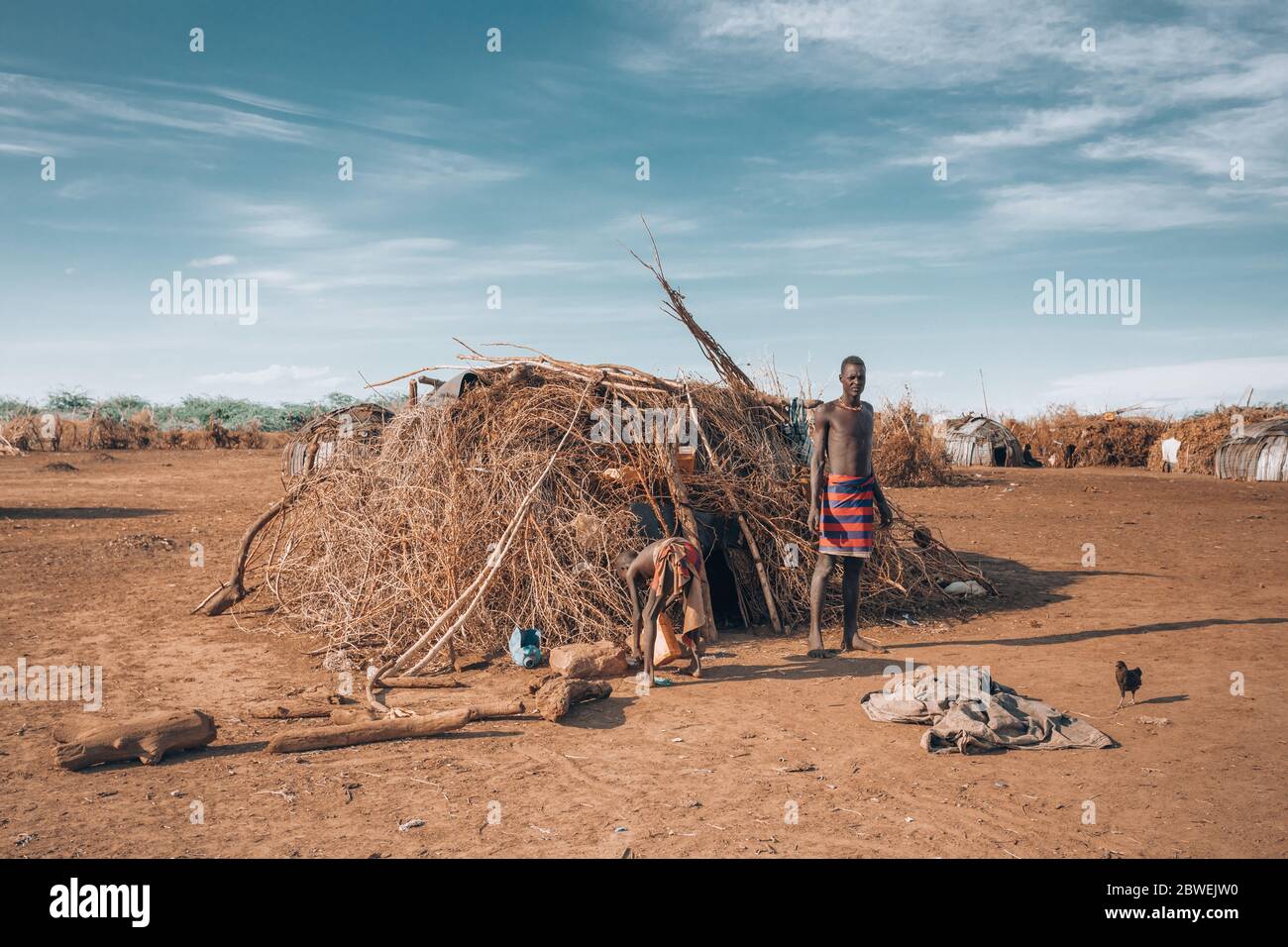 Omorate, Omo Valley, Äthiopien - 11. Mai 2019: Mann vom afrikanischen Stamm Dasanesh vor seiner Hütte. Daasanach sind die kushitischen ethnischen Gruppen, die bewohnen Stockfoto